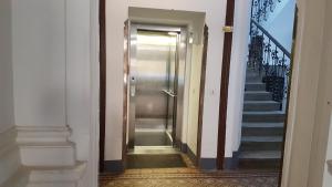 维也纳Gorgeous Viennese Apartment 10 min to City Center的走廊上设有金属门和楼梯