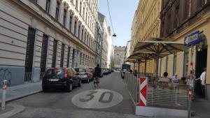 维也纳Gorgeous Viennese Apartment 10 min to City Center的骑着自行车沿着城市街道的人