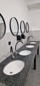 文尼察TREND HOUSE Apartments & Hostel的浴室设有四个水槽和墙上的镜子