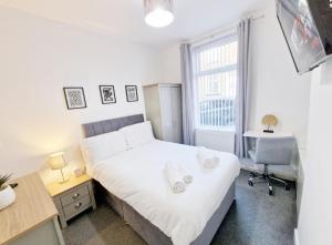 伯恩利Hudson House Burnley 3 Ensuite Rooms Available的一间卧室配有一张床、一张书桌和一个窗户。