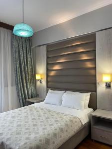 帕拉利亚狄奥尼索Maria Apartments的一间卧室配有一张大床和蓝色的灯光