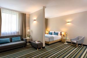 布达佩斯布达佩斯莱昂纳多酒店的酒店客房,配有床和沙发