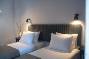 萨索斯Acropolis Hotel的酒店的客房 - 带2张带白色枕头的床