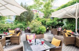 海德堡海德堡市中心莱昂纳多酒店的一个带桌椅和遮阳伞的户外庭院。