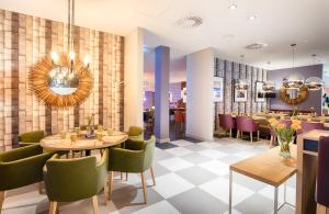 沃尔夫斯堡沃尔夫斯堡市中心莱昂纳多酒店的一间带桌椅的餐厅和一间酒吧