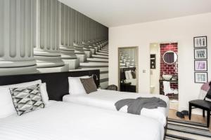 泰恩河畔纽卡斯尔纽卡斯特尔英迪格酒店的一间带两张床的卧室和楼梯
