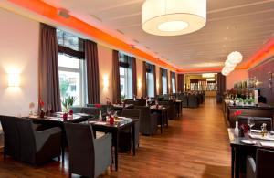 曼海姆莱昂纳多皇家曼海姆酒店的用餐室设有桌椅和窗户。
