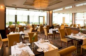 科隆科隆波恩机场莱昂纳多酒店的餐厅设有桌椅和窗户。
