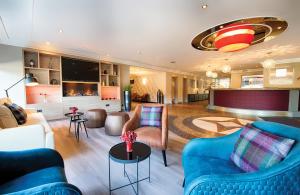 汉诺威汉诺威莱昂纳多酒店的客厅配有蓝色的沙发和椅子