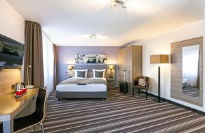 纽伦堡纽伦堡莱昂纳多酒店的酒店客房,配有床和镜子