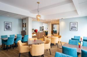 纽伦堡纽伦堡莱昂纳多酒店的一间设有蓝色椅子和桌子的等候室