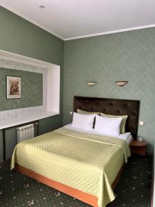 日托米尔RANDEVU的一间卧室配有一张带绿色墙壁的床
