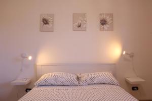 阿沃拉Casa di Sara&Anna的卧室配有一张墙上三幅照片的床
