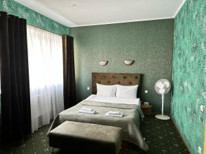 日托米尔RANDEVU的一间卧室配有一张带绿色墙壁的床