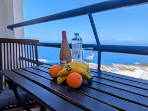 帕莱索海滩Studio Playa Paraiso Tenerife - ocean view and internet wifi optical fiber - for rent的坐在长凳上的一束香蕉和橘子