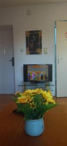 索科矿泉村Vila Lenka Sokobanja的摆在桌子上的花瓶,上面装着黄色的花