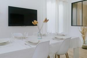 雷以桑布尔LA VILLA ALBA的白色的桌子、白色的椅子和花瓶
