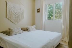 雷以桑布尔LA VILLA ALBA的窗户客房内的一张白色床