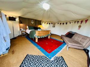 SykehouseBetween Rivers Camping @ The Old George Inn的帐篷内的房间,配有一张床和一张沙发