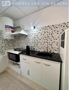 奇莱西托Residencia Céntrica的白色的厨房配有水槽和微波炉