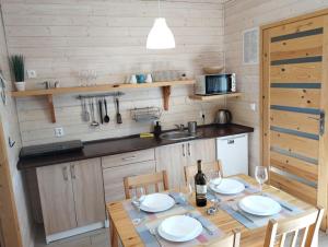 尤斯托尼莫斯基Domki na Leśnej的带桌椅的厨房和带水槽的厨房