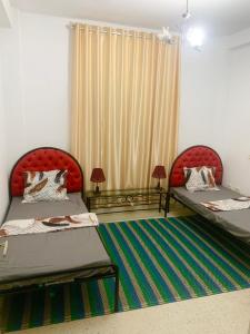 突尼斯Dream Appartement El Aouina的客房设有两张床和窗户。