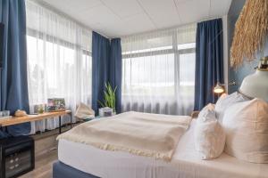 康斯坦茨Aqua Hotel的一间卧室配有一张带蓝色窗帘的大床