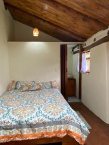 伊瓦拉Casita Hierbabuena的一间卧室设有一张床和木制天花板