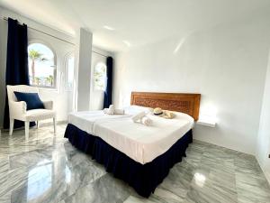 EsteponaDiletta Beach Estepona的一间卧室配有一张大床和一把椅子