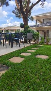 利隆圭Annavilla7 Lilongwe Aparthotel的公园里有桌子和长椅,还有树