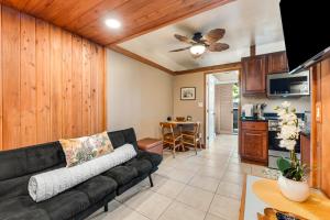 希洛Waiakea Villas 4-124的一间带黑色沙发的客厅和一间厨房