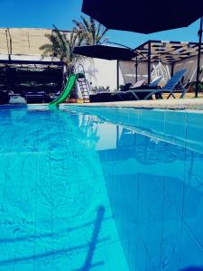 索瓦马Tala DeadSea Villa的一个带绿色水滑梯的游泳池