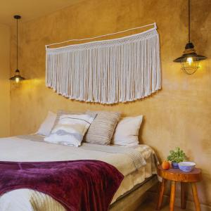 罗斯巴利勒斯Hotel Hondo的卧室配有一张挂在墙上的床和窗帘