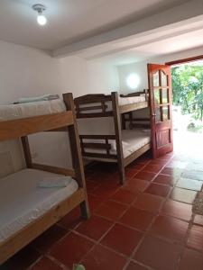 CalabazoSantuario Tayrona Hostel的一间设有几张双层床和一扇门的房间