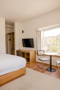 阿雷基帕La Posada del Puente的一间卧室配有一张床、一张书桌和一台电视。