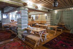 阿拉木图新布拉克度假酒店的一间设有木桌和长凳的餐厅