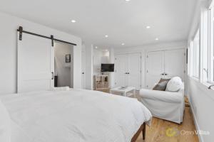 布里斯班Stunning Views by the Bay 2BR的白色的卧室配有白色的床和沙发