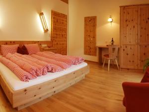 皮茨河谷阿兹尔恩瑟亚霍夫儿童农场旅馆的铺有木地板的客房内设有一间卧室和一张床。