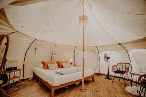 科斯比Mimosa Hill Wanderlust Woods的帐篷内一间卧室,配有一张床