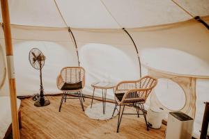 科斯比Mimosa Hill Wanderlust Woods的帐篷内的房间,配有两把椅子和一张桌子