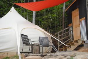 科斯比Mimosa Hill Wanderlust Woods的小屋前的帐篷和两把椅子