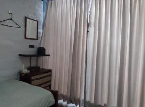 CumbayáCasa del Aguacate Cumbaya - Tumbaco的卧室配有白色窗帘和床