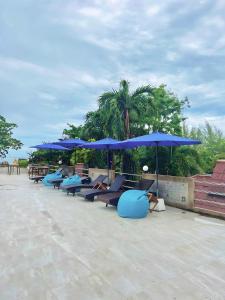 奥南海滩Days Inn by Wyndham Aonang Krabi的一把蓝色的躺椅在伞下