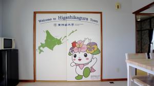 Higashikagura東神楽大学ゲストハウス的墙上挂着鲜花的凯蒂猫的海报