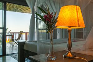 希登盖莱Naara Eco Lodge & Spa的一张桌子,上面有台灯和花瓶