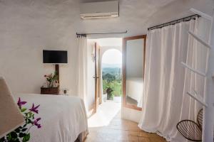 圣洛伦索巴拉菲Can Quince de Balafia - Turismo de Interior的一间卧室设有一张床和一个大窗户