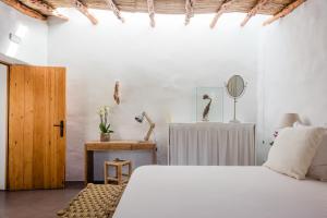 圣洛伦索巴拉菲Can Quince de Balafia - Turismo de Interior的一间卧室配有一张床和一张带镜子的桌子