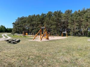 SalmeSõrve Guest House的草地上有两个秋千和长椅的公园