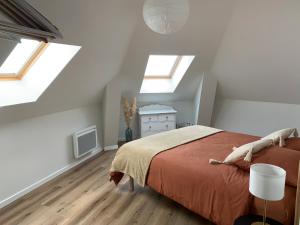 滨海布洛涅Chez Aline & Seb的一间带天窗的卧室和一张位于阁楼的床。