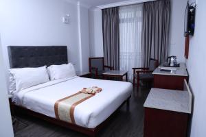 亚的斯亚贝巴奇尼迪酒店的酒店客房带一张床、一张桌子和椅子